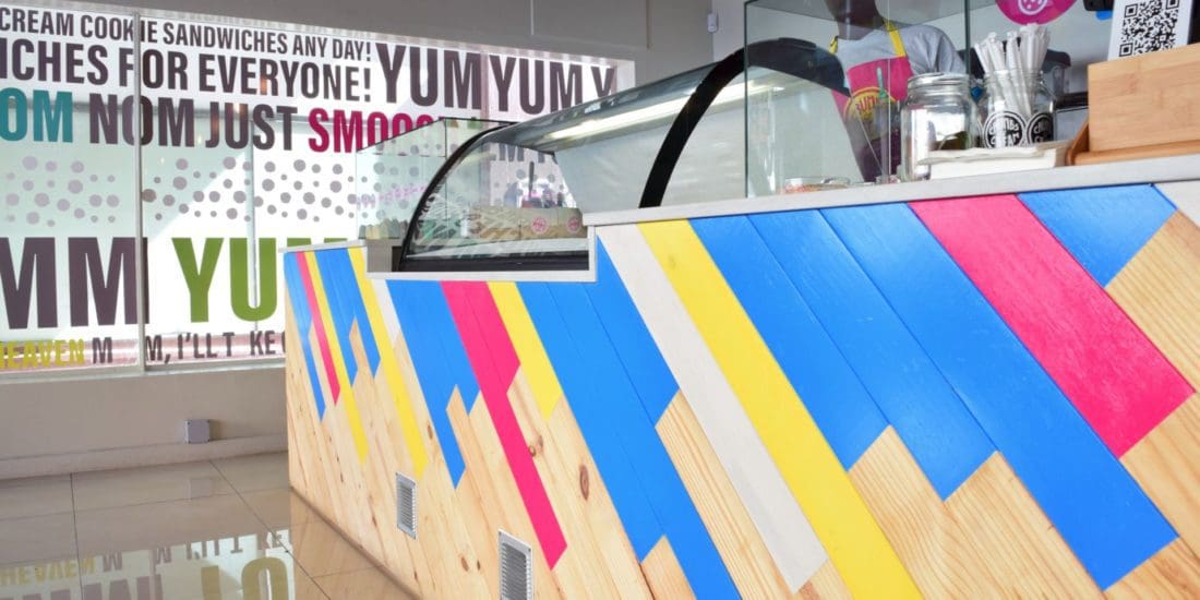 Interior view of Crumbs & Cream store design featuring colourful seating and gelato counter