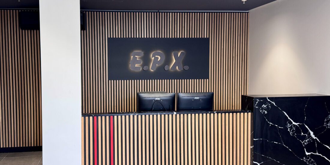 reception desk with finishes of natural oak slats black onyx stone and EPX backlit logo
