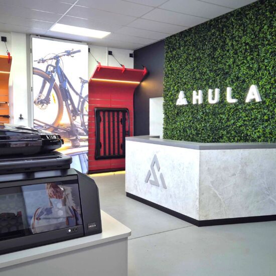 illuminated 3d logo on a plant wall behind reception desk
