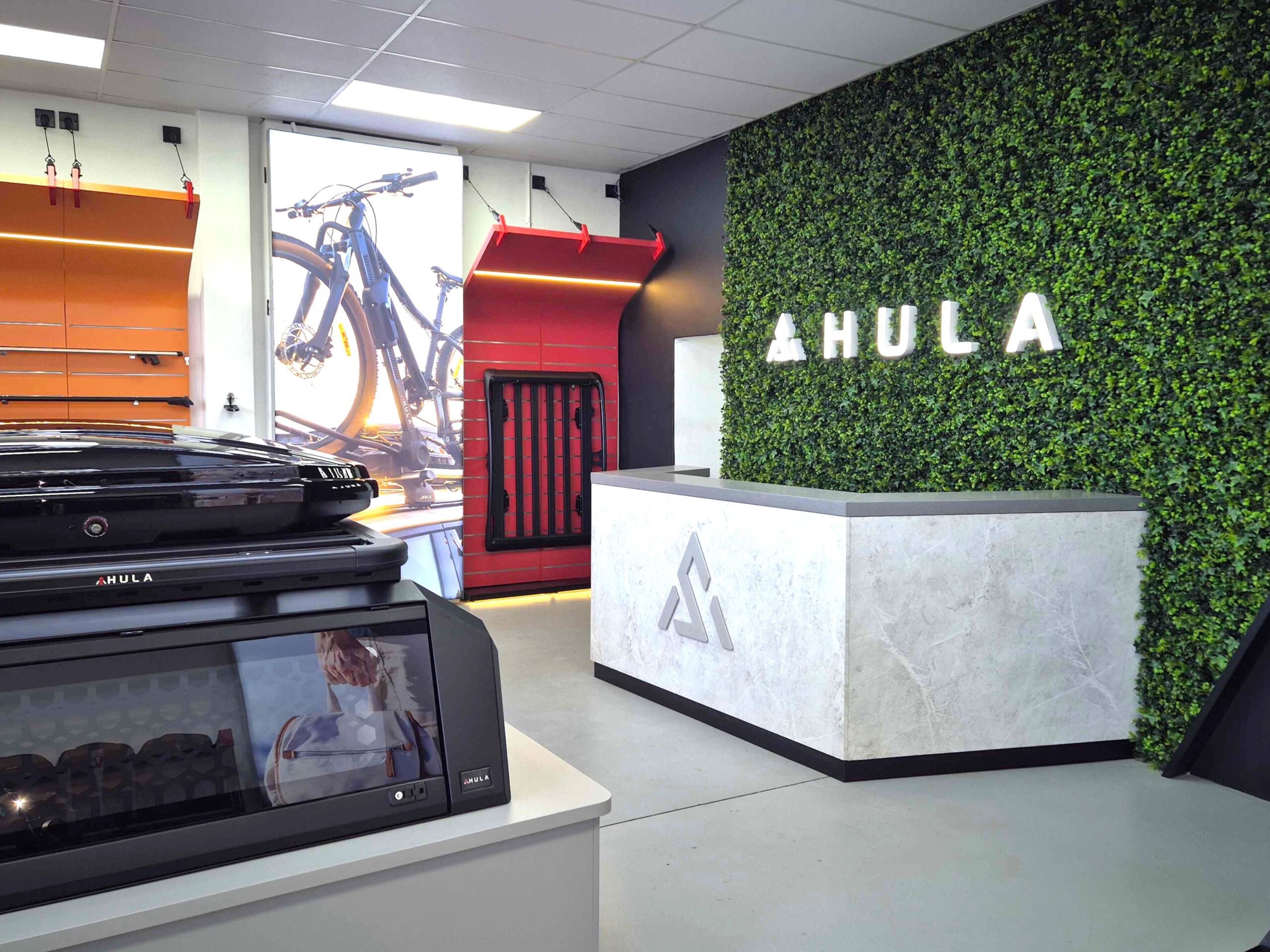 illuminated 3d logo on a plant wall behind reception desk